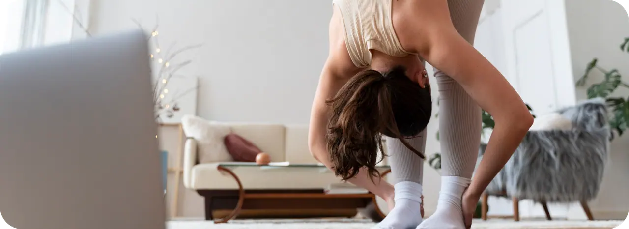 Pessoa a realizar uma postura de yoga numa aula semanal.