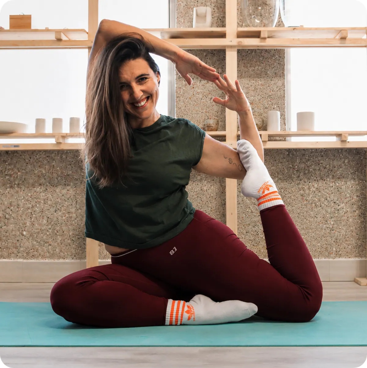 Tânia Frausto, enfermeira de reabilitação e instrutora de yoga, numa posição de alongamento sobre um tapete.
